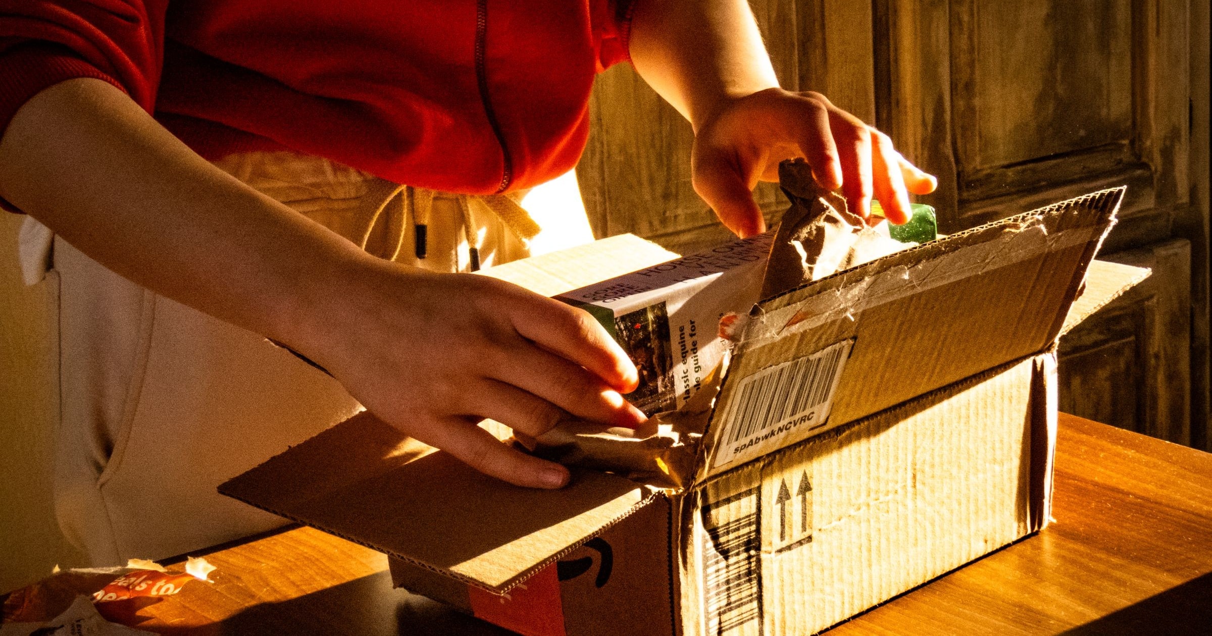 Hands unboxing a parcel in warm light
