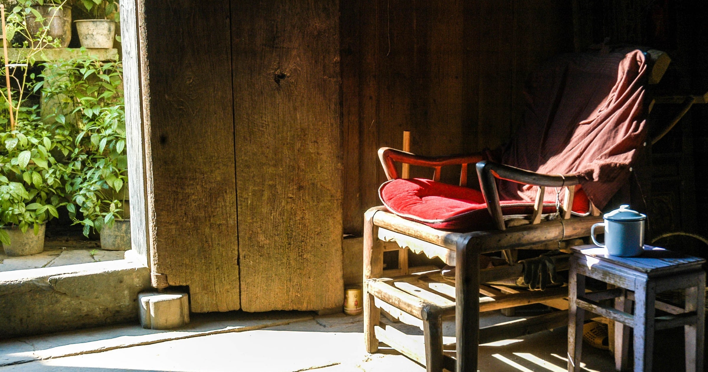 A red cloth draped over an old wooden chair in a dark doorway.