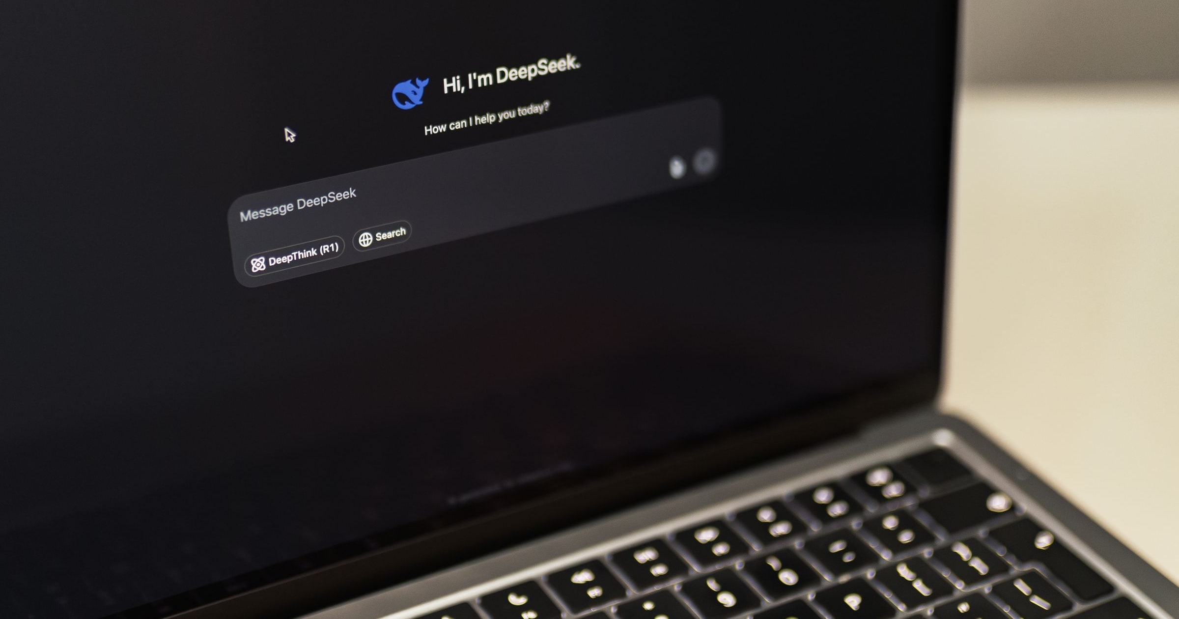 MacBook laptop displaying a DeepSeek AI chat interface on screen