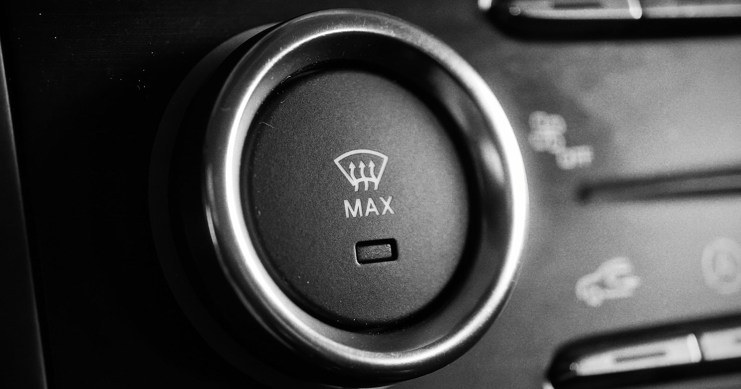 Black-and-white close-up of a car climate-control dial labelled MAX