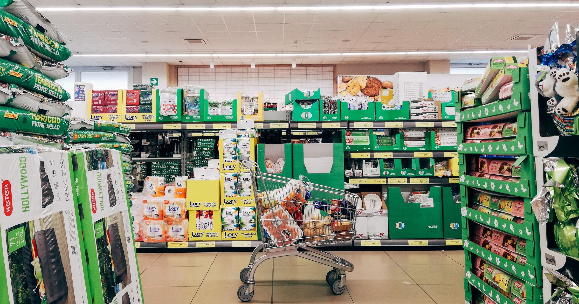 A shopping trolley left in a stocked supermarket aisle