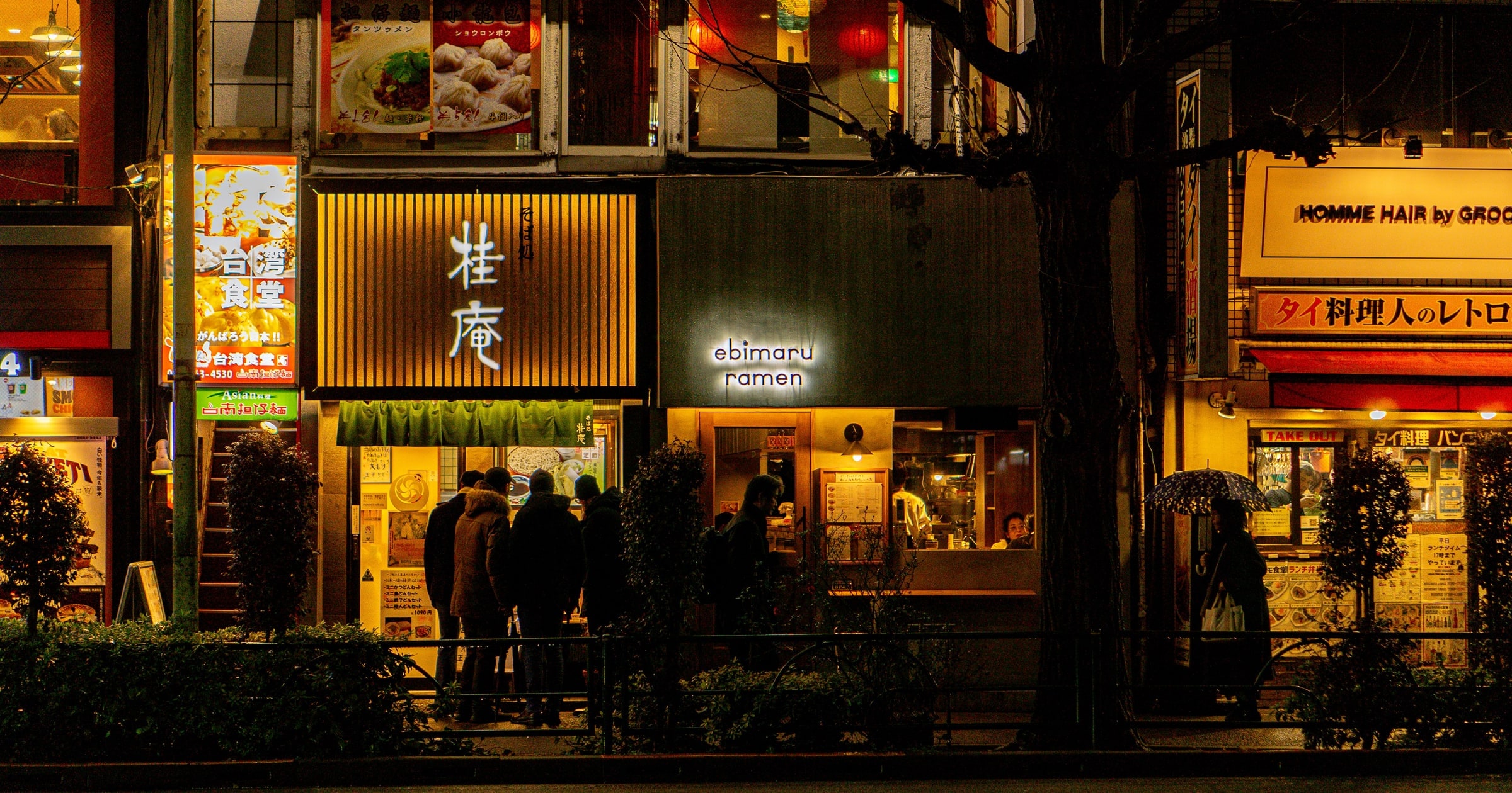 People waiting outside a ramen shop at night