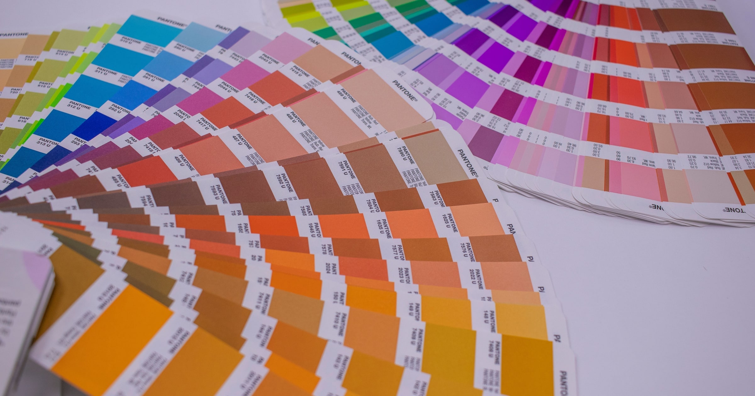 A fan of Pantone colour swatches in bright hues.